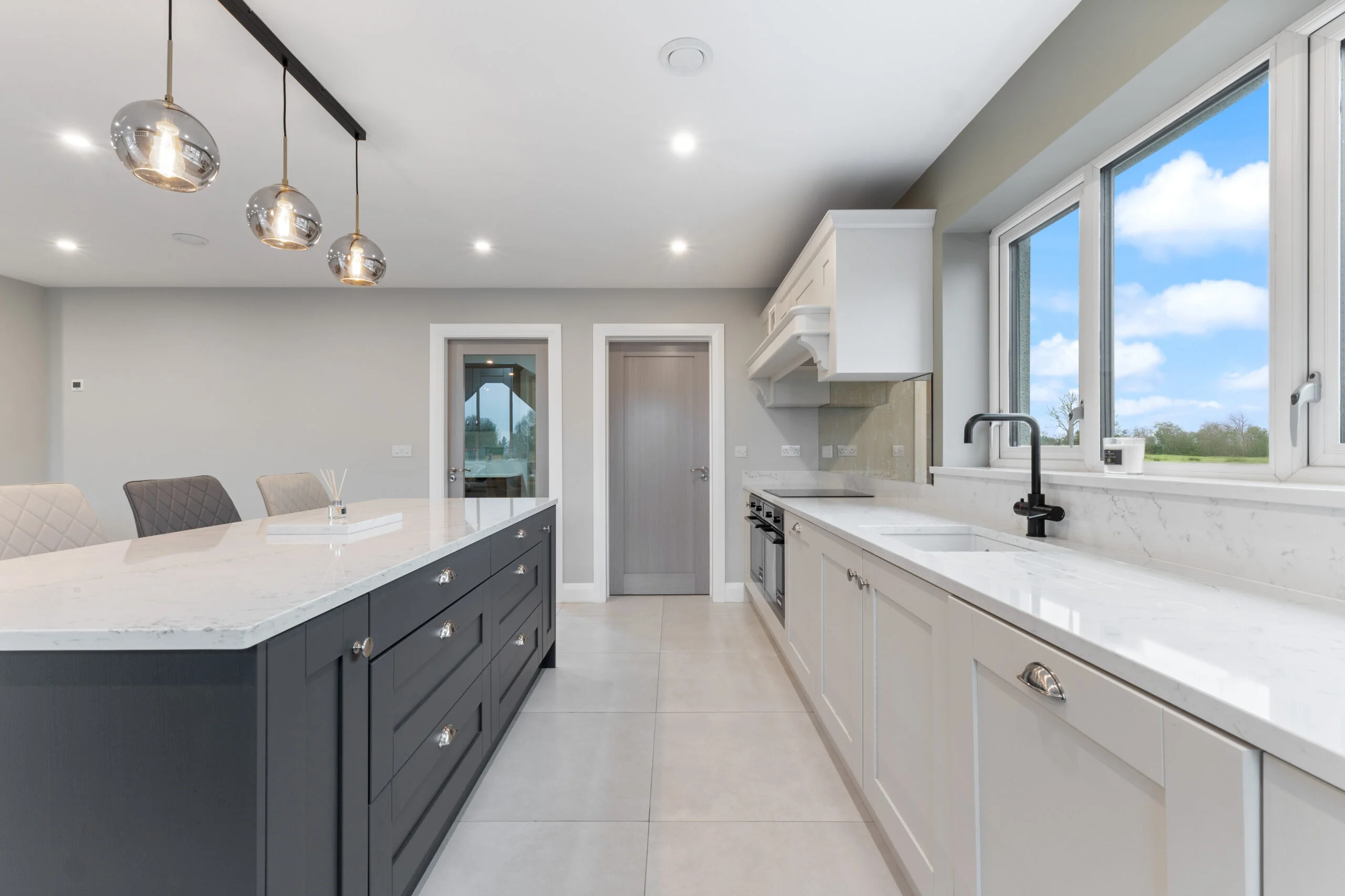 White and dark grey shaker kitchen with marble quartz worktop, island and globe pendant lights