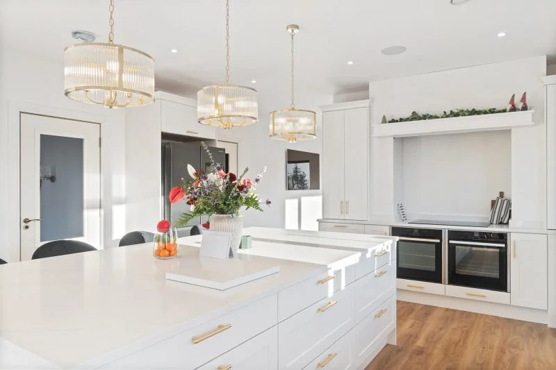 White shaker kitchen island gold handles quartz worktop brass pendants